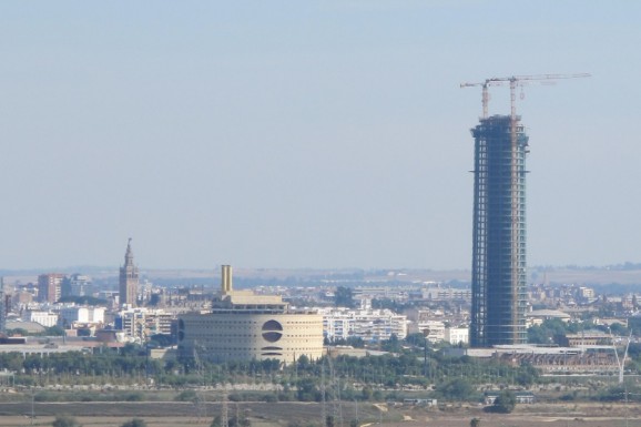 This view of the Seville skyline shows the Giralda (left) and Puerta Triana (centre) dwarfed by the Pelli tower