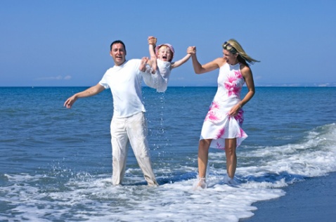 Family enjoying a day at the beach © iStock