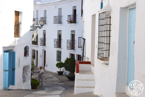 A narrow, cobbled street in Frigiliana winds between whitewashed houses under the warm Andalusian sun © Michelle Chaplow