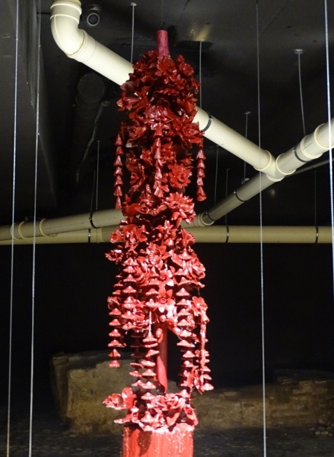 Red candle with carved flowers and hanging details.  © Fiona Flores-Watson